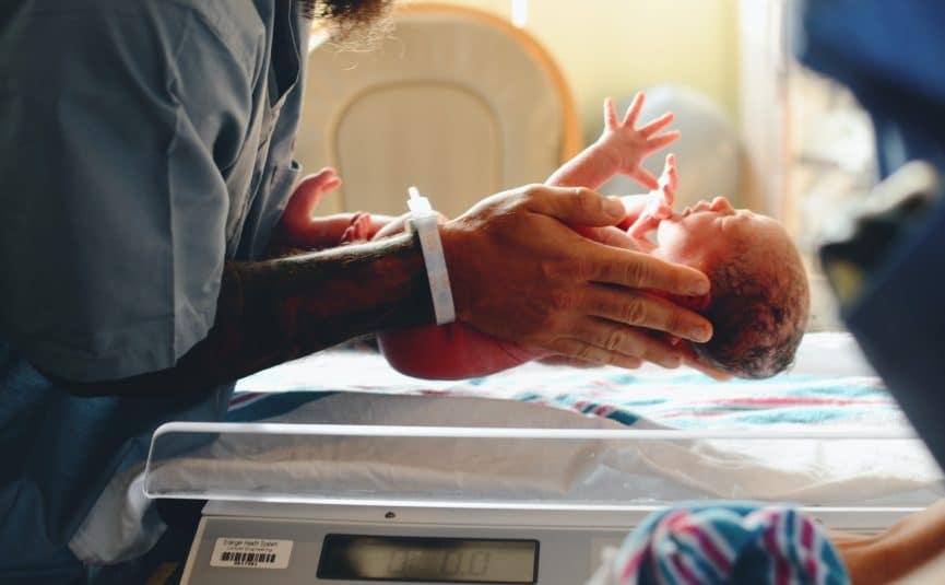 a man holding a baby that's just been born